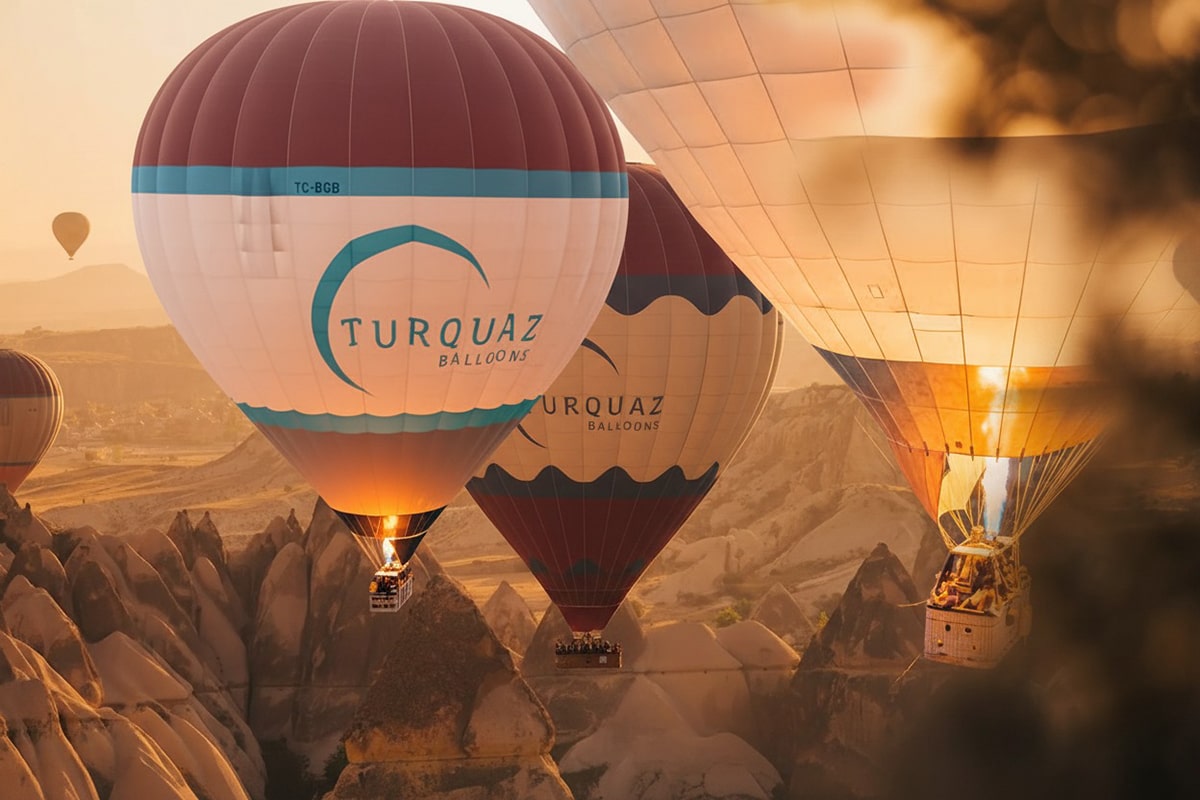 Hot air balloon floating over Cappadocia at sunrise with a view of volcanic valleys and fairy chimneys
